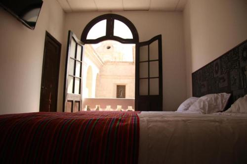 a bedroom with a large bed and an open window at Catedral in Arequipa