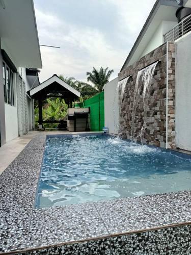 a swimming pool in front of a house at Homestay Sungai Besar with Private Pool RUMAH HANA in Sungai Besar