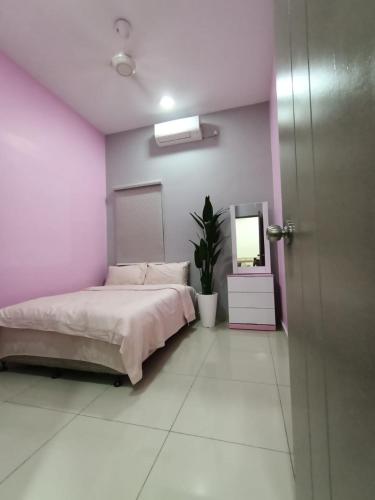 a bedroom with a bed and a pink wall at Homestay Sungai Besar with Private Pool RUMAH HANA in Sungai Besar