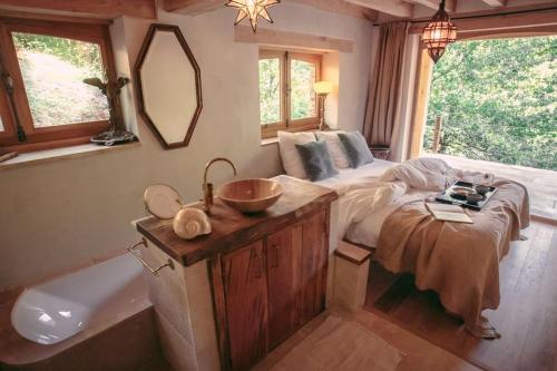 - une chambre avec un lit, un lavabo et une baignoire dans l'établissement Private Estate with 3 Lake Houses, Sauna & Hot-tub, à Castelnau-de-Mandailles