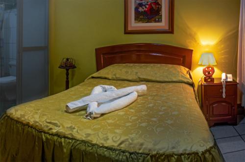 a bed with two white towels laying on it at HOSTAL MONUMENTAL a Media Cuadra de la Plaza Mayor in Cajamarca