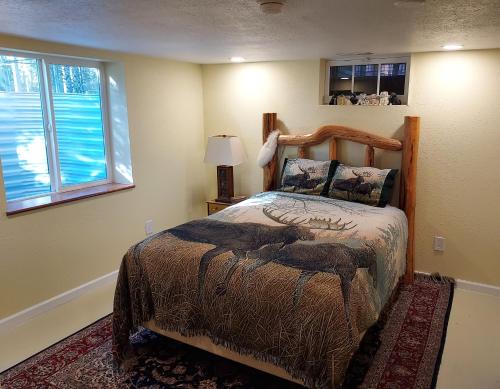 - une chambre avec un lit et une couette en cerf dans l'établissement Swan Mountain View-Private Basement Suite/10 acres, à Kalispell