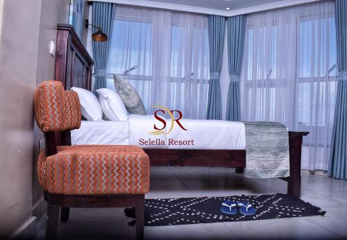 a hotel room with a bed and a chair and a sign at Selella Resort in Kisumu