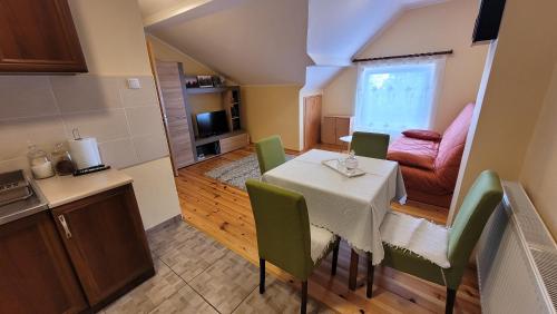 a kitchen and a dining room with a table and chairs at Zlatibor Apartmani DM Tornik in Zlatibor