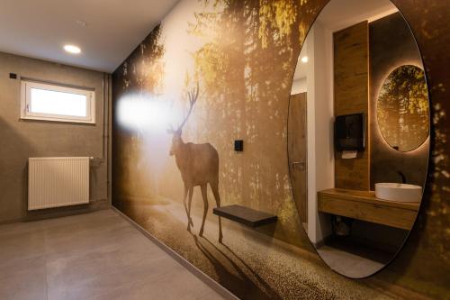Hotel am Sonnenlandpark في Lichtenau: حمام به لوحة غزلان على الحائط