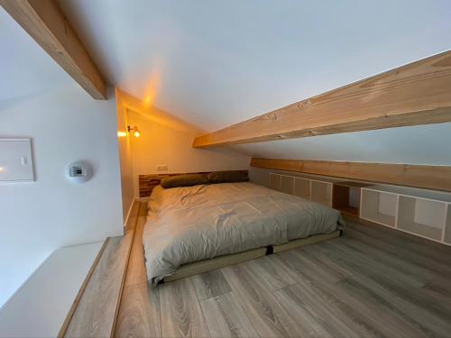 - une petite chambre avec un lit et du parquet dans l'établissement L'annexe, au Teich