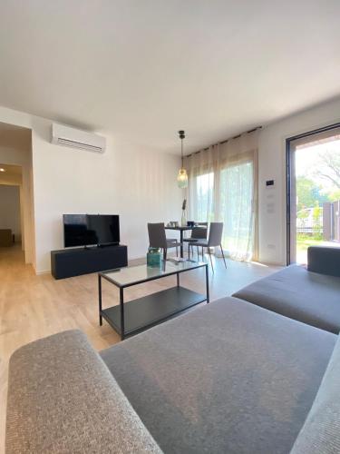uma sala de estar com um sofá e uma mesa em Cortemaggiore 4D Luxury-Flexrent Abissinia em Riccione