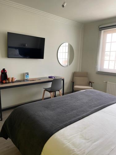 a bedroom with a bed and a desk with a television at Almasur Express Punta Arenas in Punta Arenas