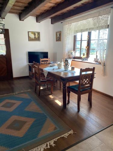 a dining room with a wooden table and chairs at A nyugalom háza in Szentbékkálla