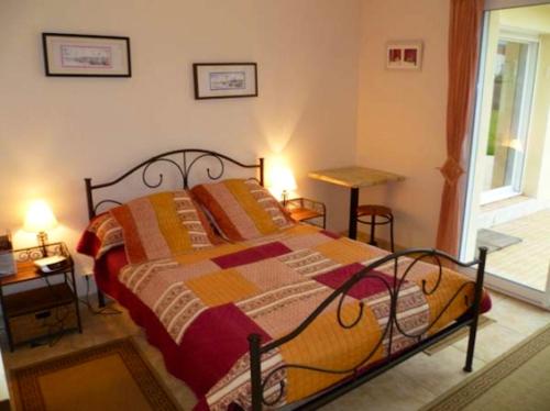 a bedroom with a bed with a colorful quilt at Villa de 5 chambres avec piscine privee jacuzzi et jardin clos a Saint Nic in Saint-Nic