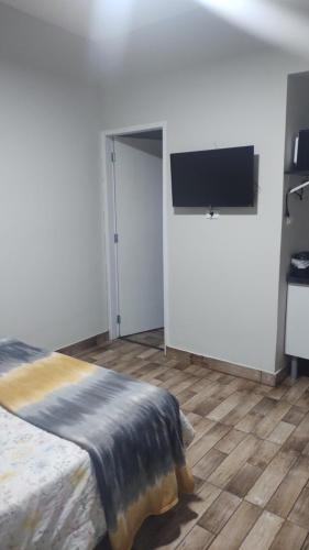 1 dormitorio con 1 cama y TV de pantalla plana en Catumbi Studio 5, en São Paulo