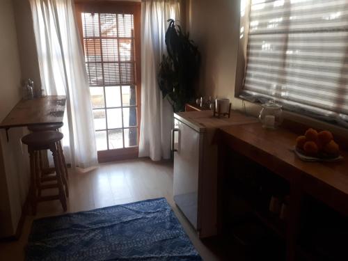 a kitchen with a counter and two windows and a table at Cozy Sarel Cilliers street in Kroonstad