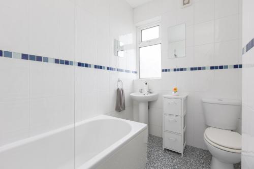 Baño blanco con aseo y lavamanos en Charles Alexander Short Stay - Ansdell House, en Blackpool
