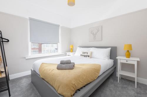 Un dormitorio blanco con una cama con una manta amarilla. en Charles Alexander Short Stay - Ansdell House, en Blackpool