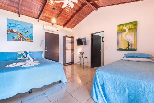 a bedroom with two beds and a tv at Hotel Villas de la Selva in Manuel Antonio