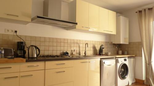 a kitchen with white cabinets and a washing machine at Maison médiévale de charme à Baden in Baden