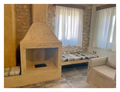 a living room with a fireplace with a couch and a bed at KESEMI in Kalavrita