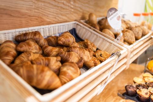 a bunch of loaves of bread in baskets on a table at NunoHotel in Cologne