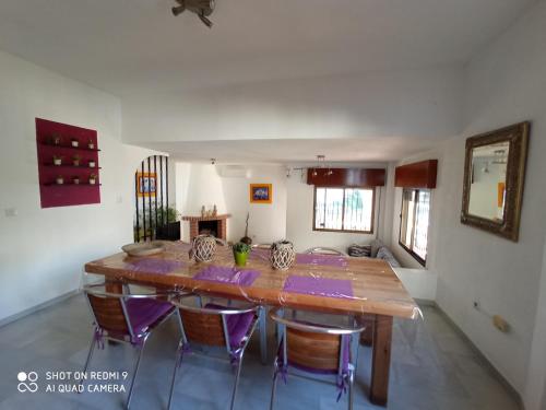 a dining room with a wooden table and chairs at House in a cove Almunecar in Almuñécar