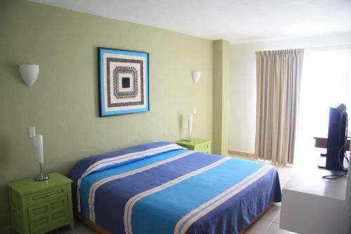 a bedroom with a bed and a television in it at Amapas Apartments Puerto Vallarta in Puerto Vallarta