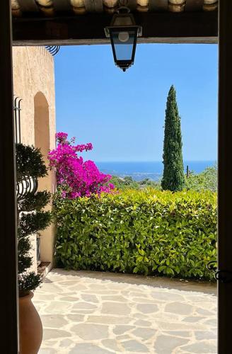 a view of a garden from a door with flowers at Les Hauts de la Riviera in Cabris
