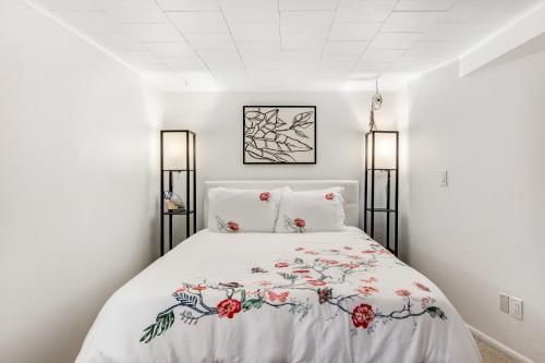 a white bedroom with a bed with a floral bedspread at Hidden Gem in Green Lake in Seattle
