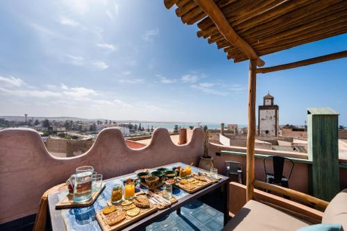 a table with food on a balcony with a view at MAMA LOVA Essaouira in Essaouira