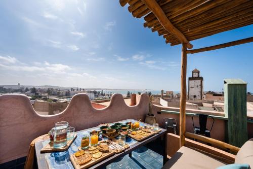 uma mesa com comida numa varanda com vista em MAMA LOVA Essaouira em Essaouira