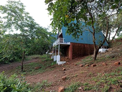 a house with a blue roof on a hill at Porsu in Canacona