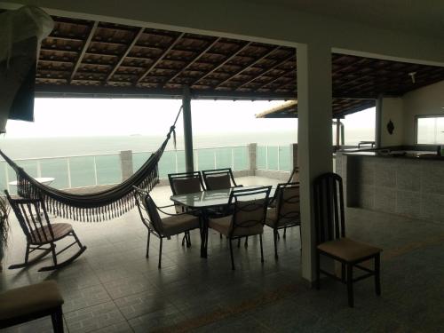 里约热内卢Hostel Vista do Mar的一间带吊床和桌椅的用餐室
