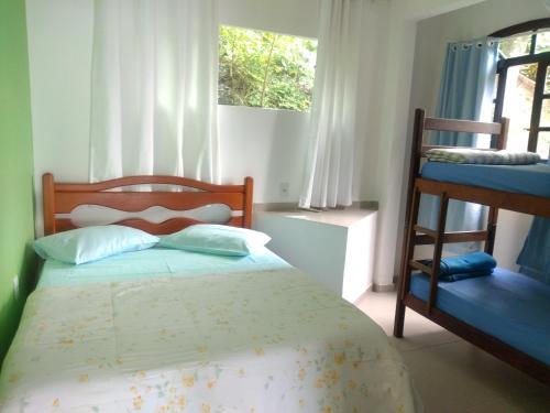 里约热内卢Hostel Vista do Mar的一间卧室，配有一张床和两张双层床