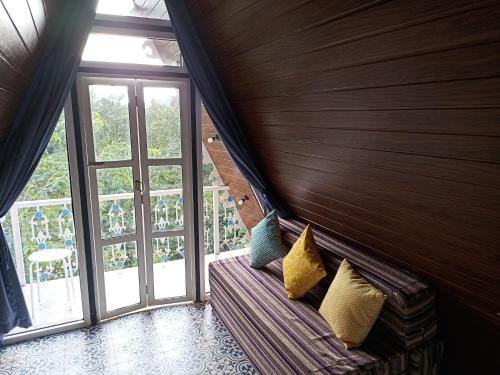 a room with a couch with pillows and a window at Porsu in Canacona