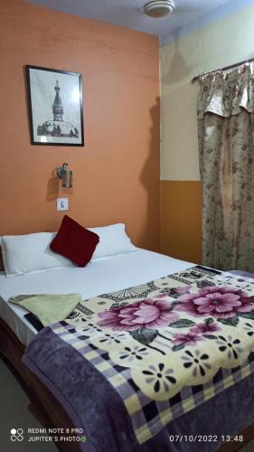 a bedroom with a bed with a flower patterned blanket at The Lumbini Village Lodge in Lumbini