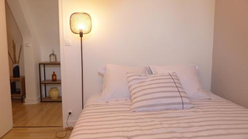 a bed with white pillows and a lamp in a room at Maison médiévale de charme à Baden in Baden