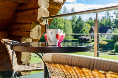 a table with two coffee cups on a balcony at Villa Rose & SPA in Mežciems