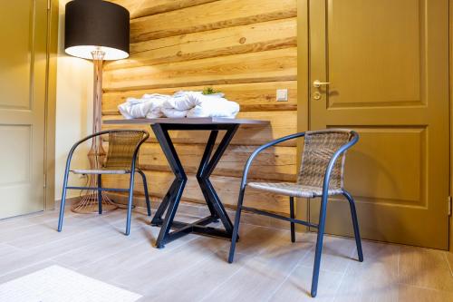 a table with two chairs and a lamp in a room at Villa Rose & SPA in Mežciems