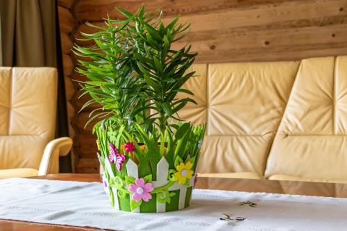 a green vase with flowers on a table at Villa Rose & SPA in Mežciems