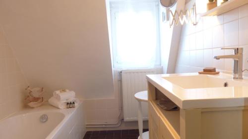a white bathroom with a tub and a sink at Maison médiévale de charme à Baden in Baden