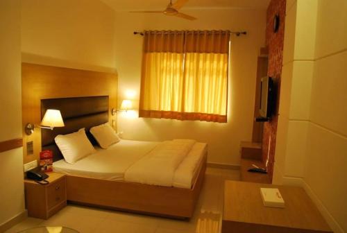 a hotel room with a bed and a window at Hotel Arina Inn in New Delhi