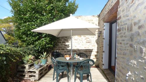 a table and chairs under an umbrella on a patio at Maison médiévale de charme à Baden in Baden