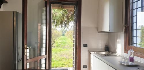 a kitchen with an open door to a yard at Charming country house by Anthea Homes in Casale sul Sile