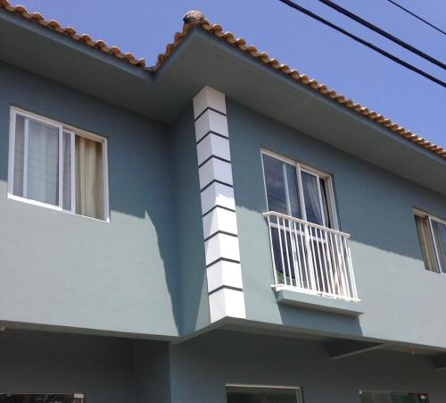 Casa azul y blanca con balcón en Moradas do Pedro, en Palhoça