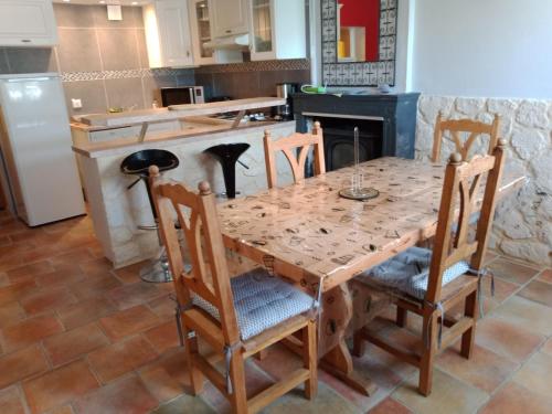 Il comprend une cuisine avec une table en bois et des chaises. dans l'établissement Maison au calme, à Saint-Michel-en-lʼHerm