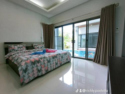 a bedroom with a bed and a large window at Richly's​ Pool​ villa​@Phitsanulok​ in Phitsanulok