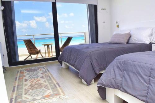 a bedroom with two beds and a view of the ocean at Ocean front Villa Marlin, best location in hotel zone #109 in Cancún