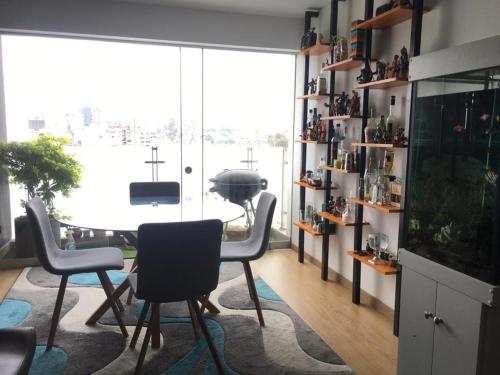 a dining room with a table and chairs and a large window at Precioso cuarto dentro de un apartamento centrico compartido in Lima