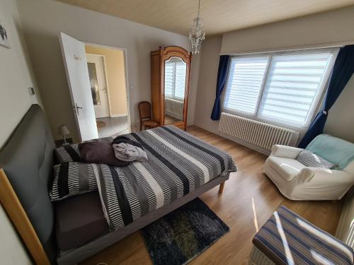 ein Schlafzimmer mit einem Bett und einem Stuhl darin in der Unterkunft Villa Beau Site in Saint-Maurice