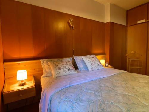 a bedroom with a bed with two lamps on tables at Casa Loria - Appartamento con Giardino in San Martino di Castrozza