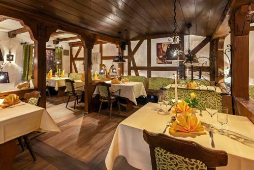 a restaurant with white tables and chairs and wooden ceilings at Landhotel Albers in Schmallenberg