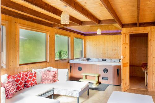 a living room with a couch and a hot tub at Stunning 4-Bedroom Country House with Hot Tub & Sauna near Loch Lomond in Glasgow